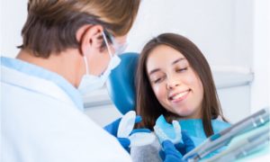 The dentist offers a dental splint to the patient.